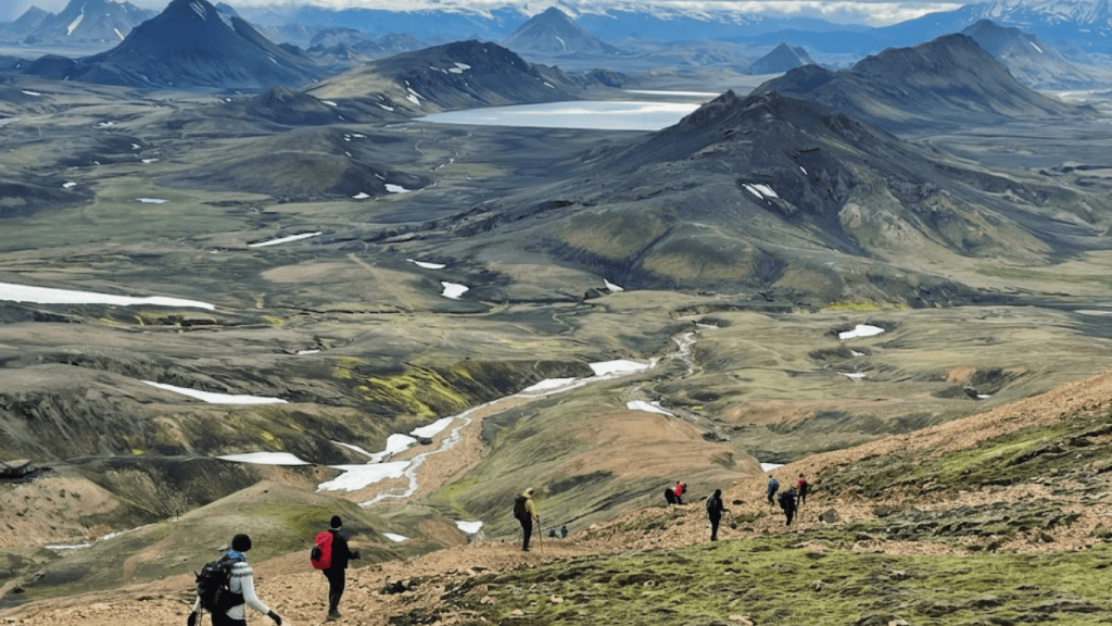 Hikers trekking across colorful volcanic landscapes on the Laugavegur Trail with mountains, rivers, and valleys