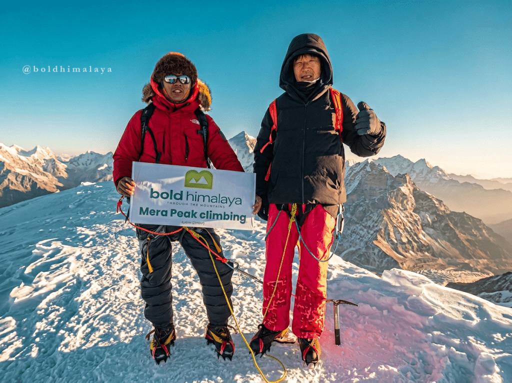 Climbers holding Bold Himalaya banner at the summit of Mera Peak