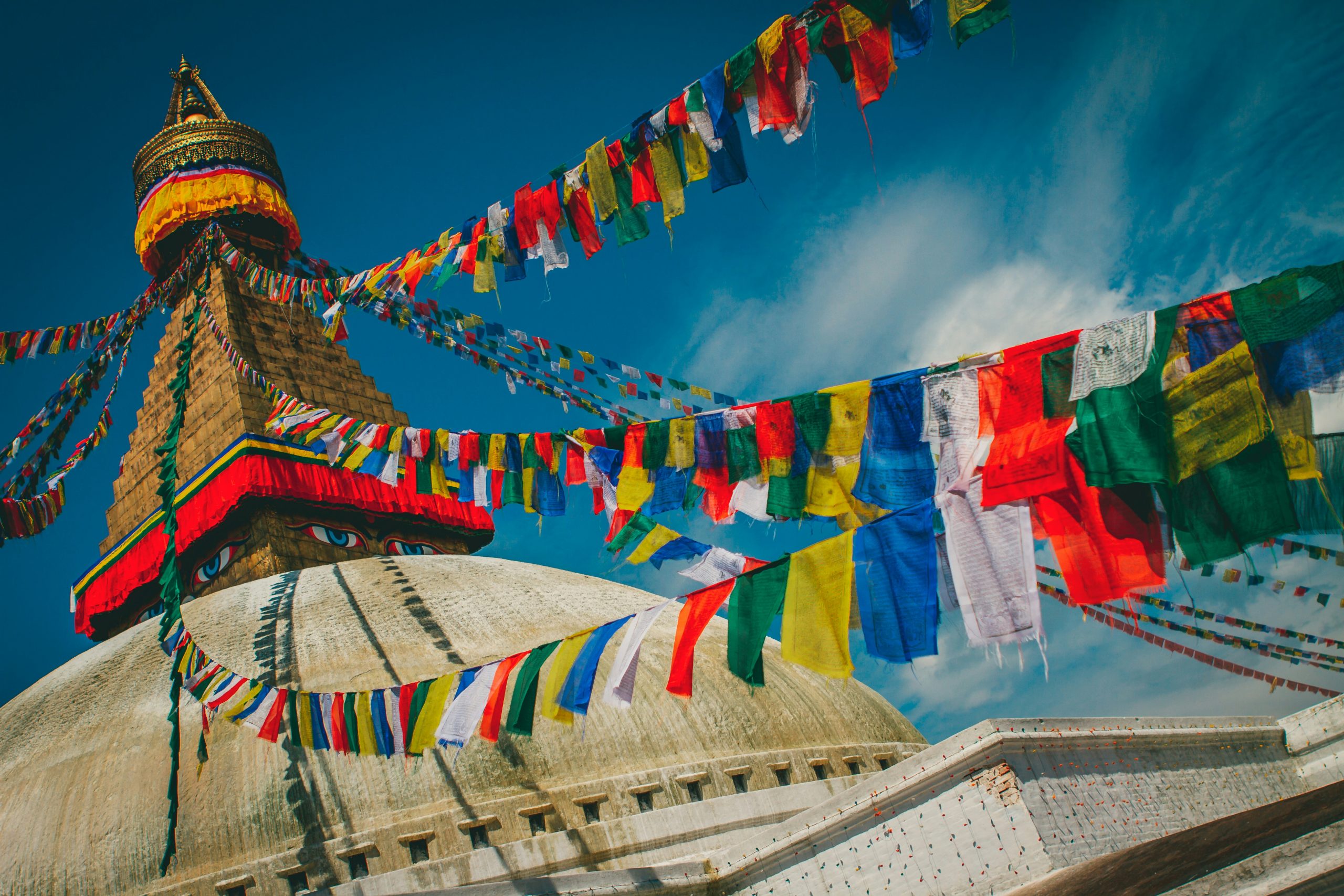 Colorful prayer flags flutter above the sacred grounds of Swayambhunath Stupa in Kathmandu, Nepal.