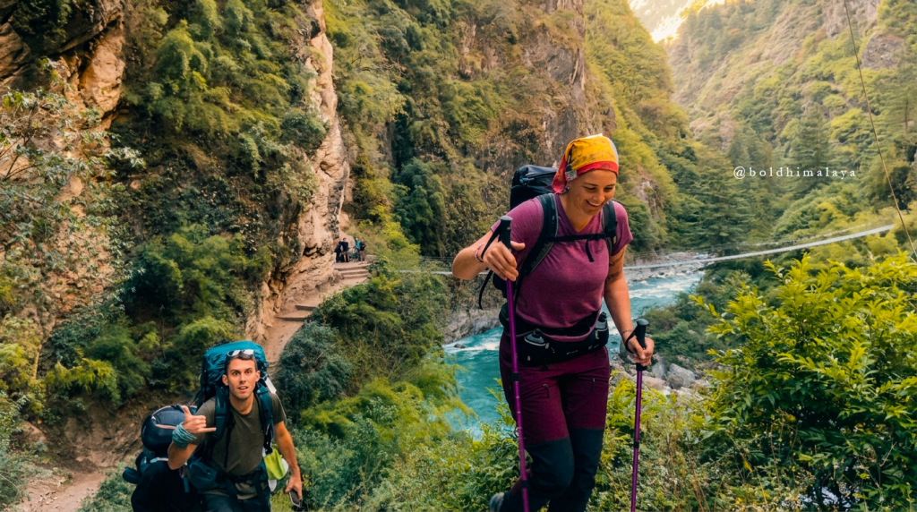Trekkers hiking along a narrow trail on the Manaslu Circuit Trek in monsoon