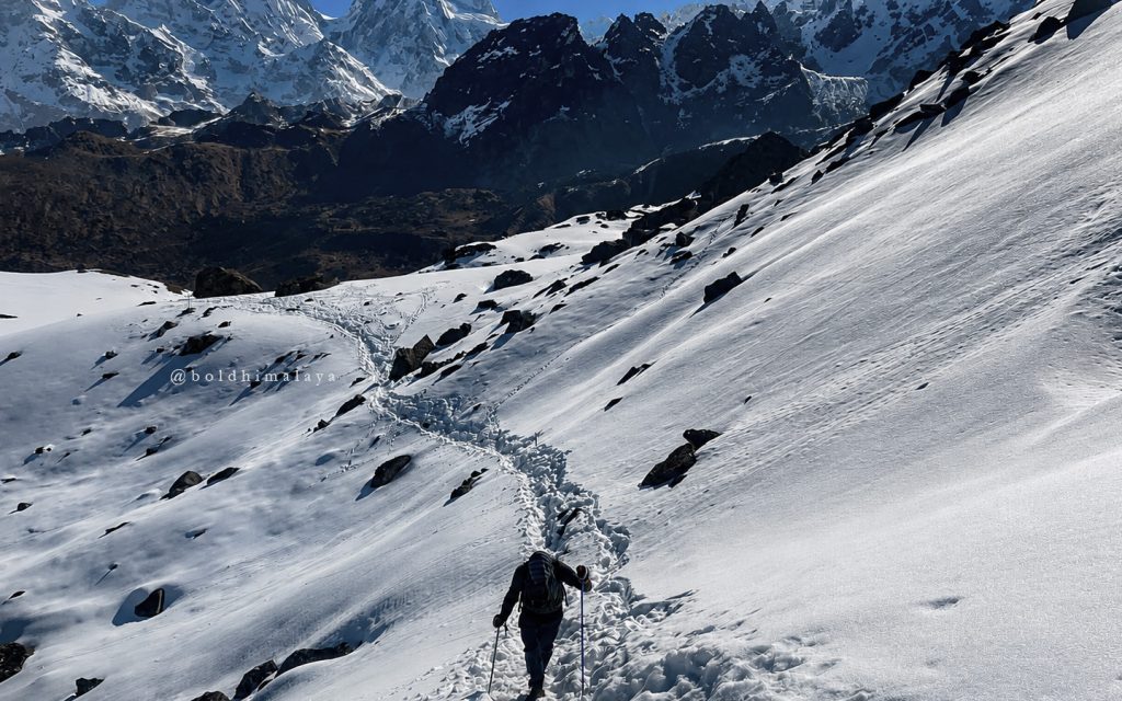 The adventurous walk through a snow-covered Himalayan mountain trail, showcasing the Kanchenjunga Trek difficulty.