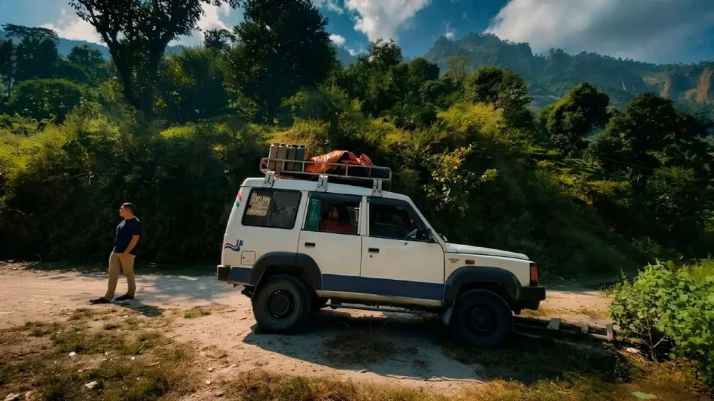 A shared jeep parked on a scenic mountain road with trekking gear on the roof.